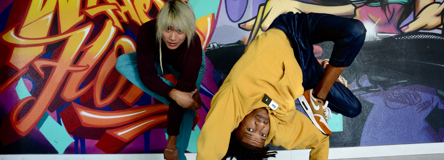 Anthony Le aka Bboy Chopz and Jason Toney aka Bboy Raw Skeleton in Breaking Dance Freeze in front of Graffiti mural at School of Breaking.