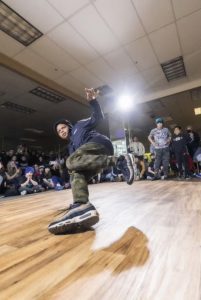 Youth competitive breaker on dancefloor with background spotlight